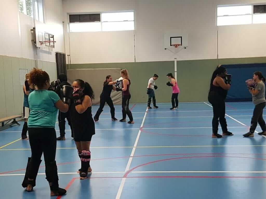 Een groepsles bokszaktraining met bokshandschoenen in een sporthal